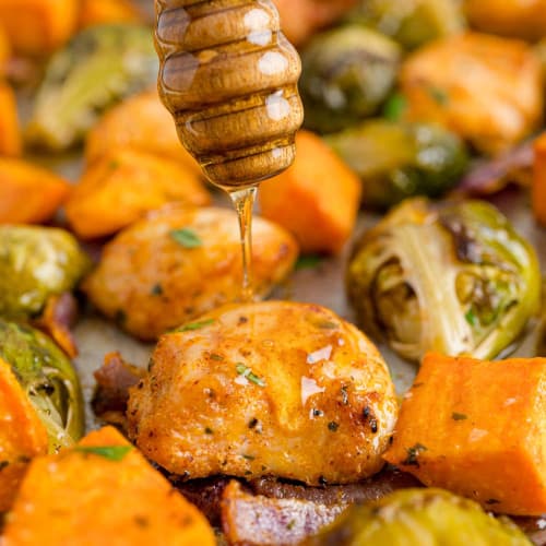 Hot honey chicken sheet pan dinner with honey being drizzled on.