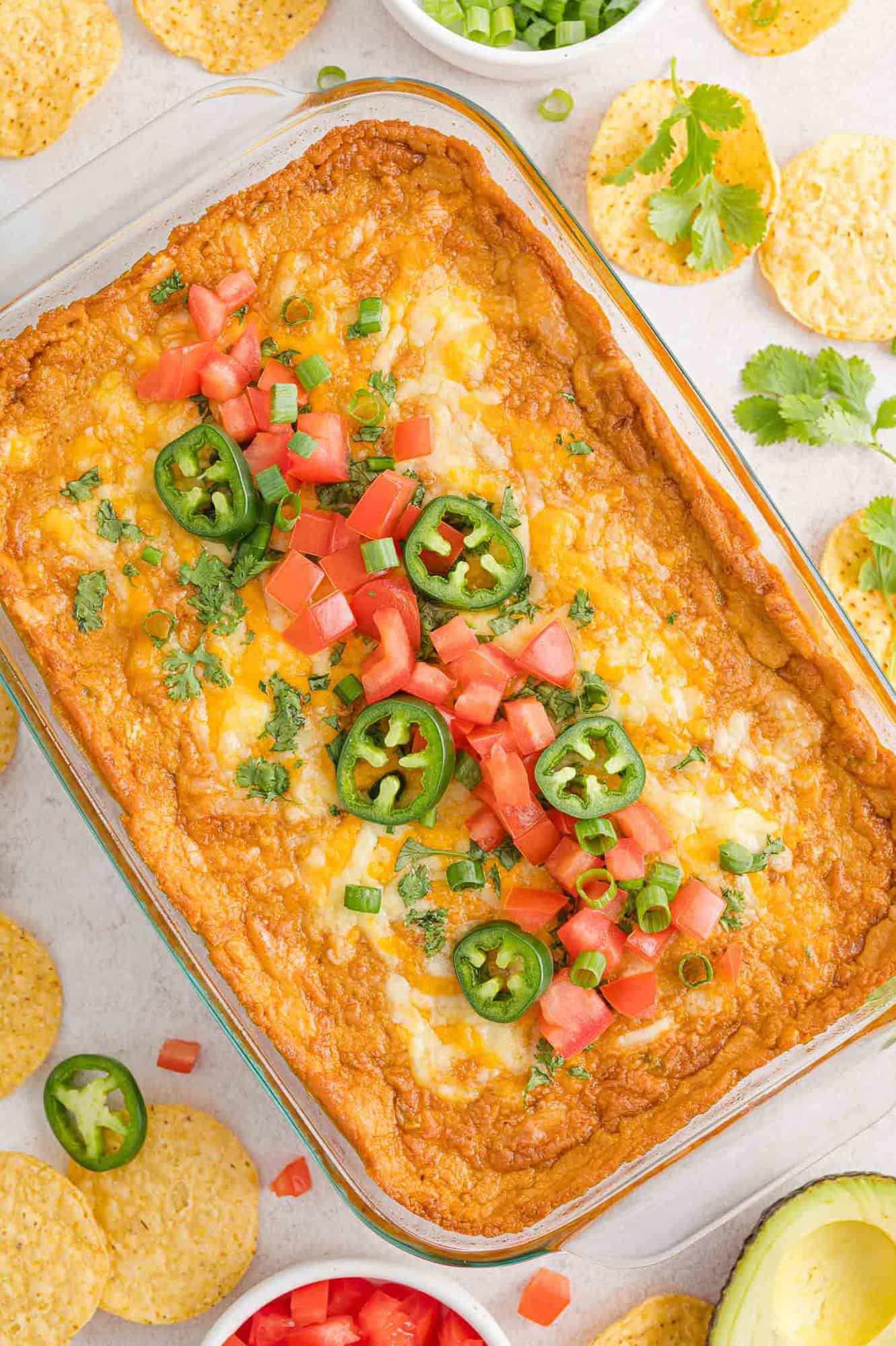 Refried bean dip in a 9x13 baking dish.