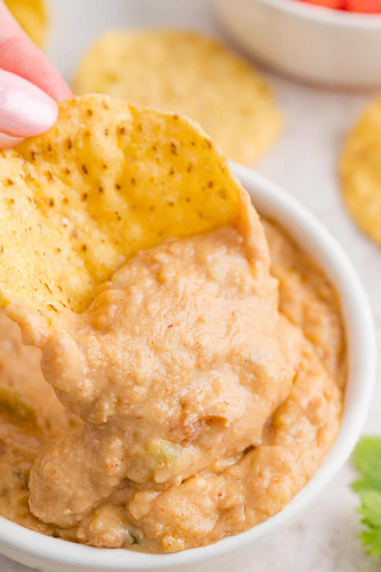 Bean dip in a small bowl with a chip.