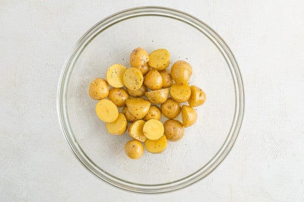 Seasoned potatoes in a glass bowl.