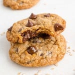 Two whole wheat chocolate chip cookies, one with a bite out of it.