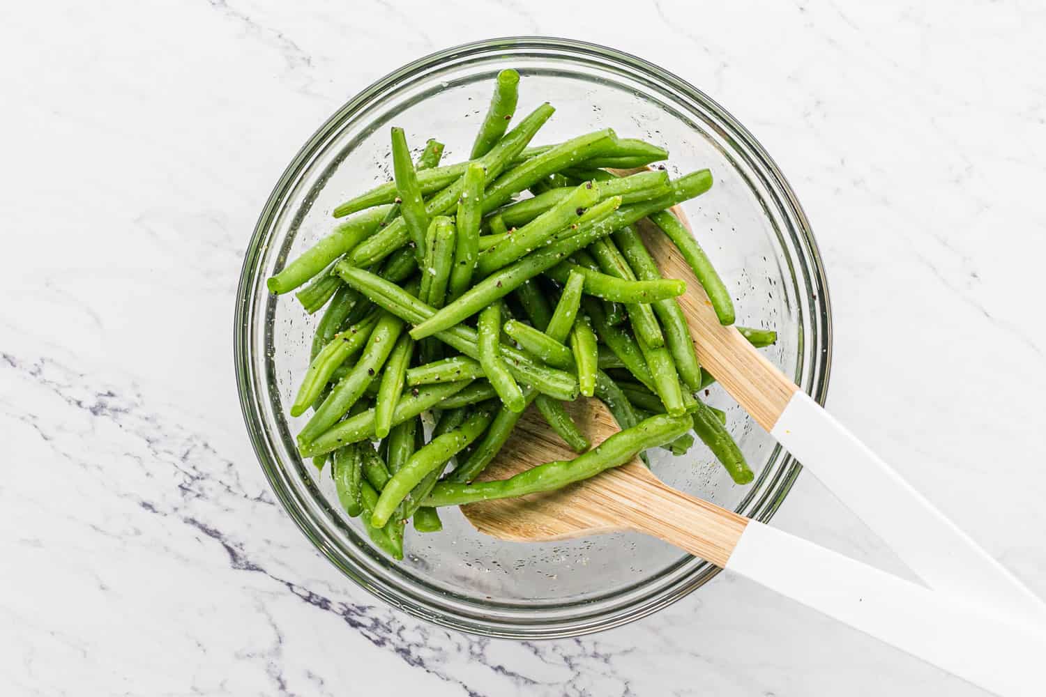 Beans being tossed with seasoning.