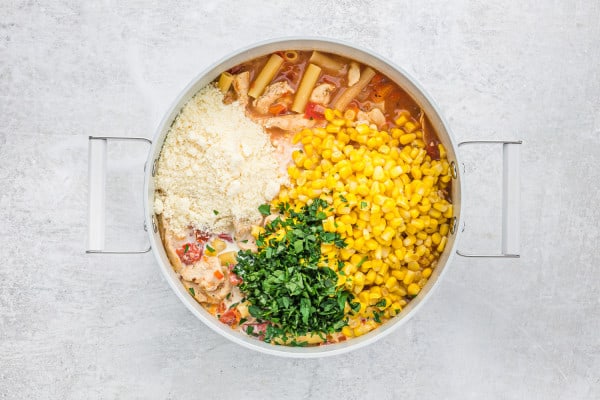 Corn, cheese, and herbs added to pan.
