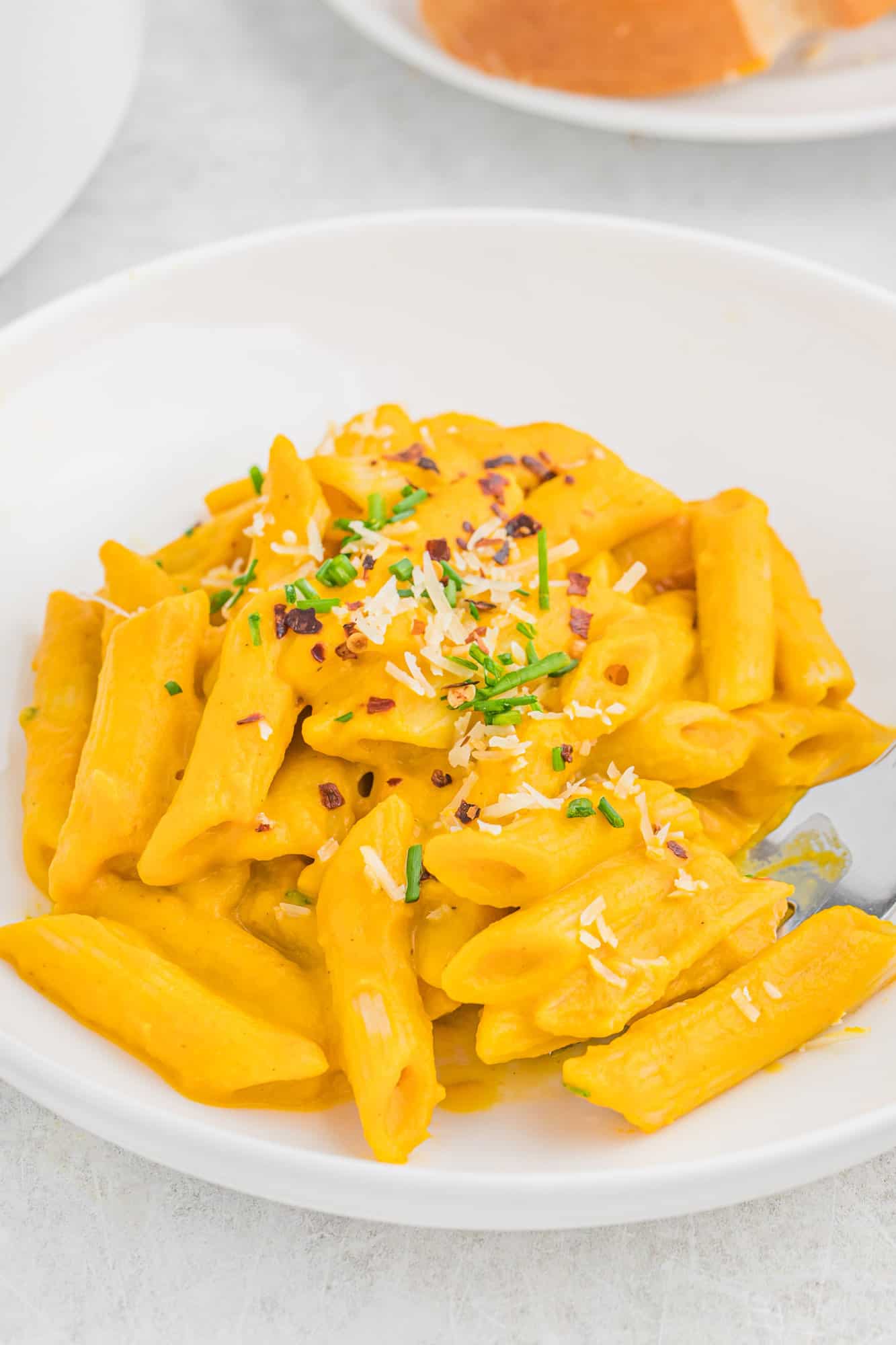 Pasta with carrot pasta sauce in a white bowl.