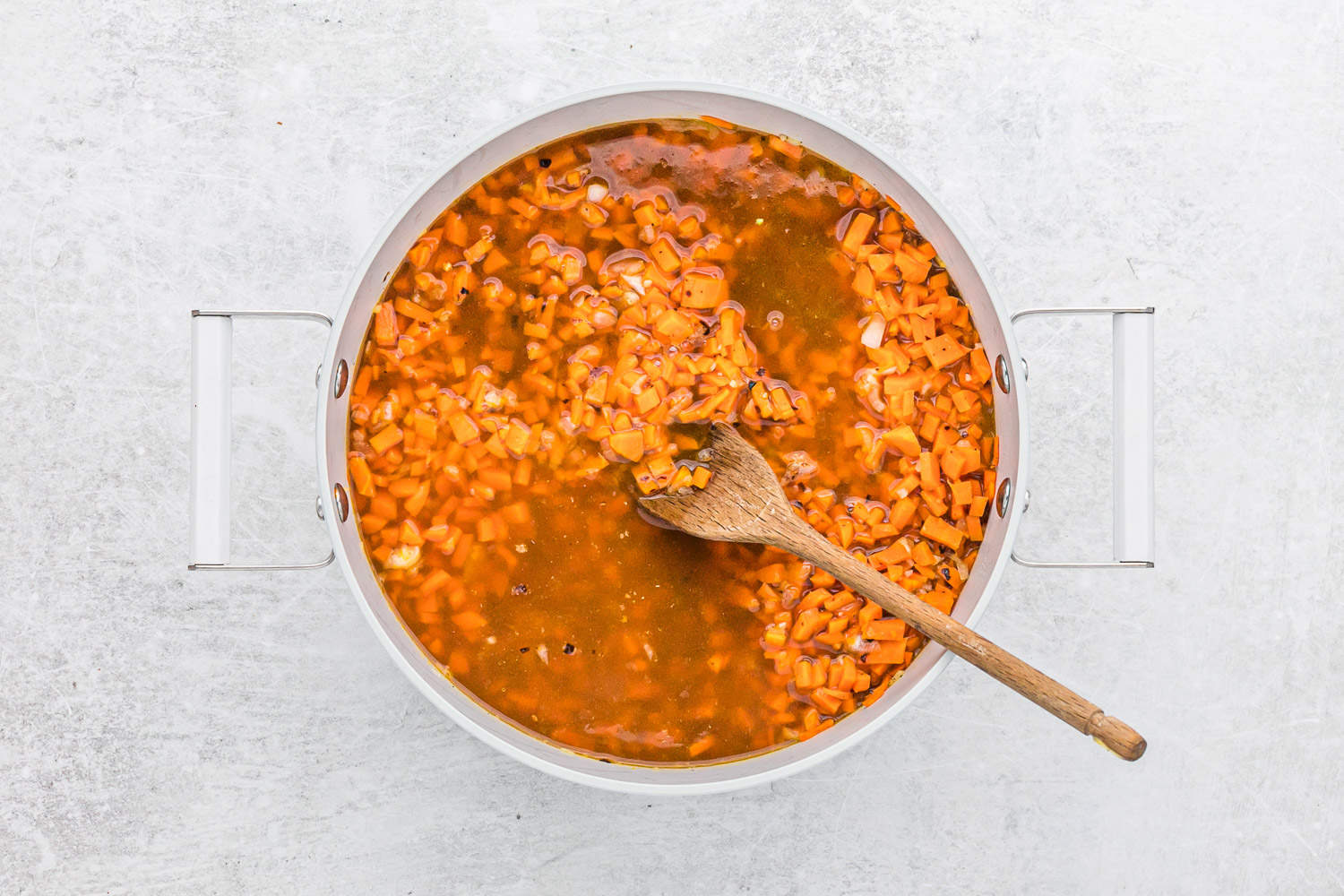 Carrots and broth in pan.