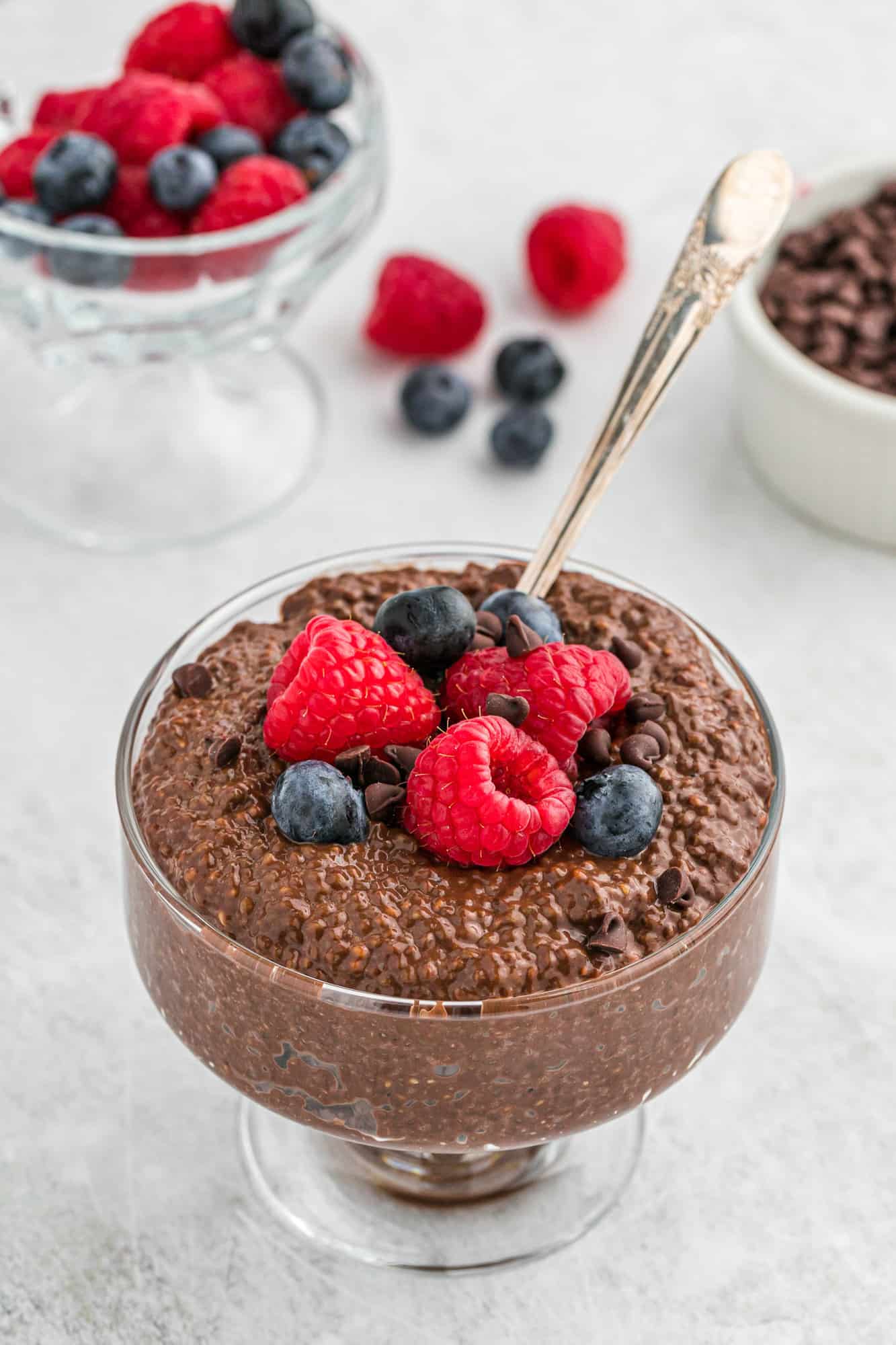 Chocolate chia pudding and berries, with spoon.