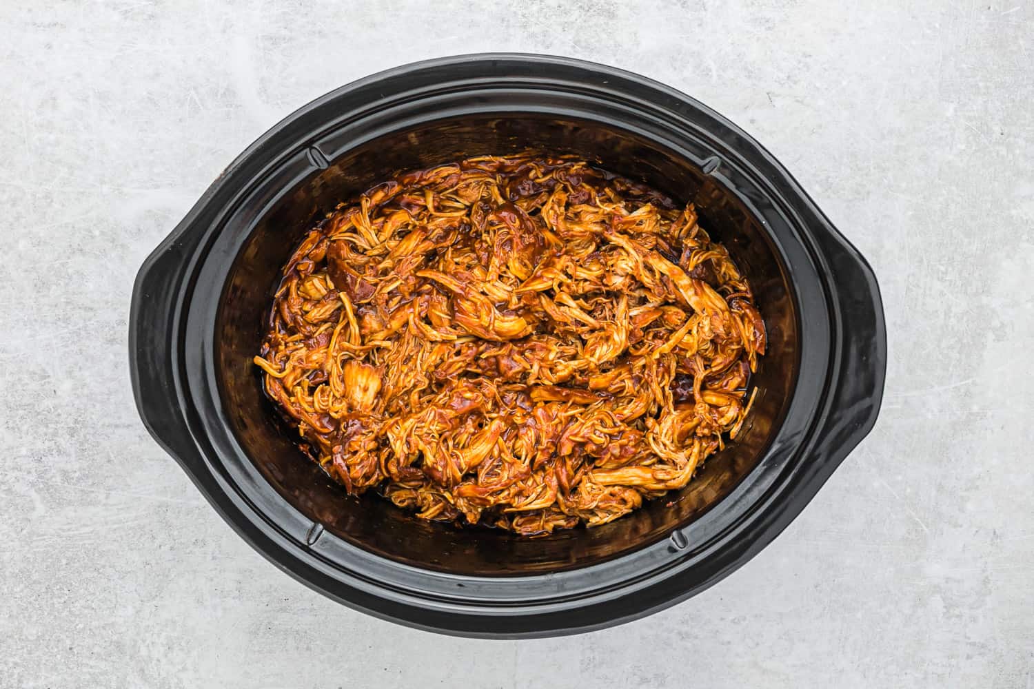 Shredded bbq chicken in a slow cooker.