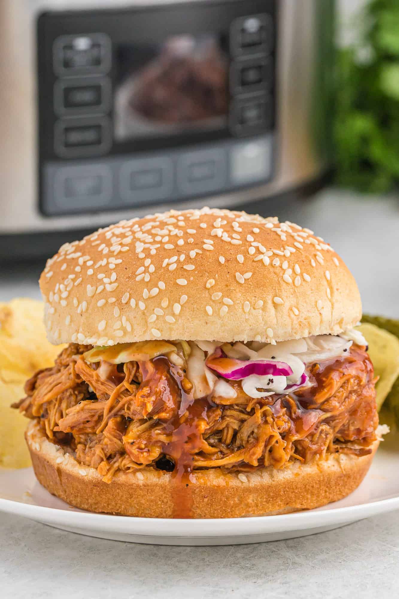 Crockpot BBQ chicken on a bun with coleslaw.