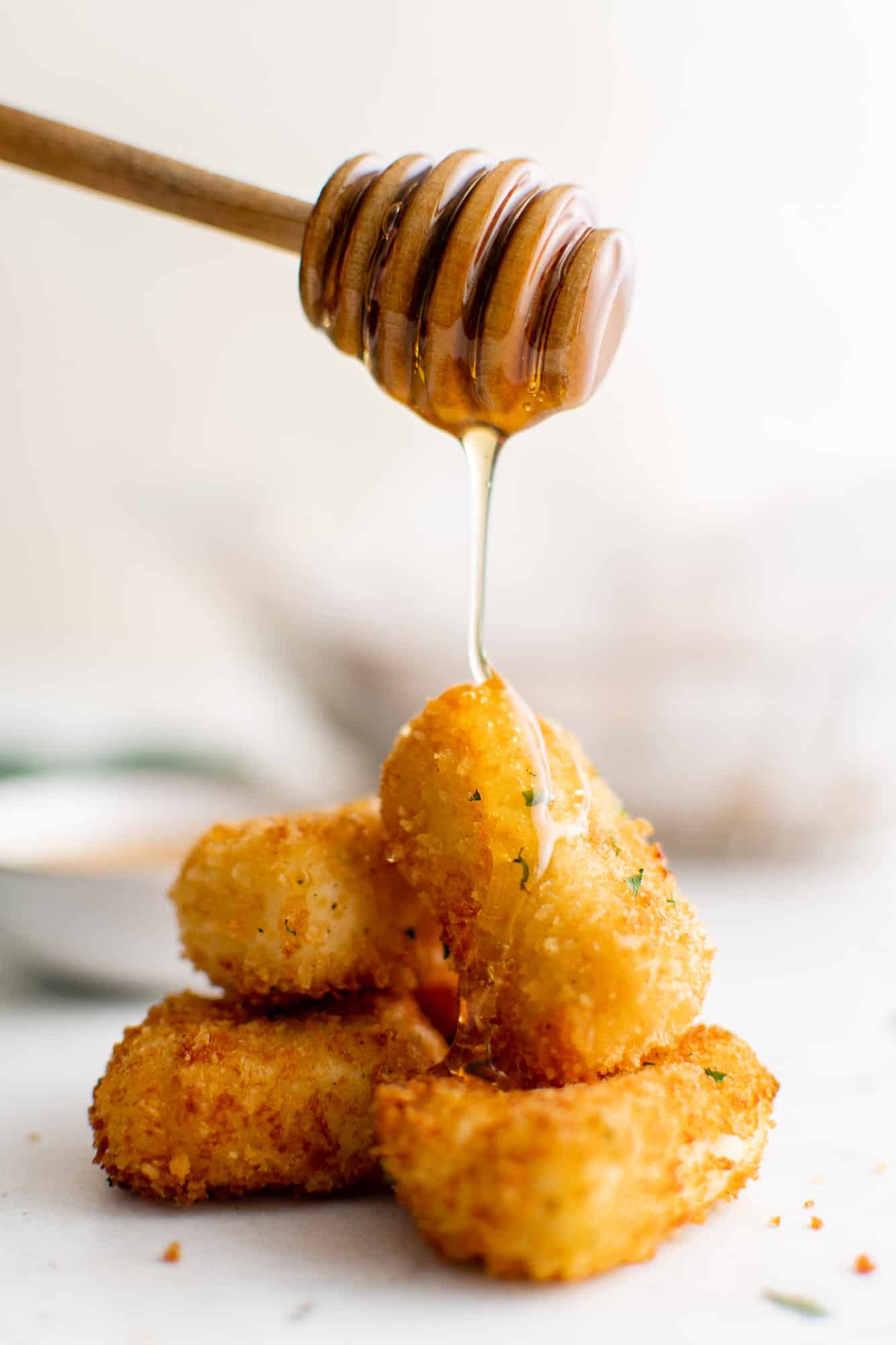 Goat cheese being drizzled with honey.