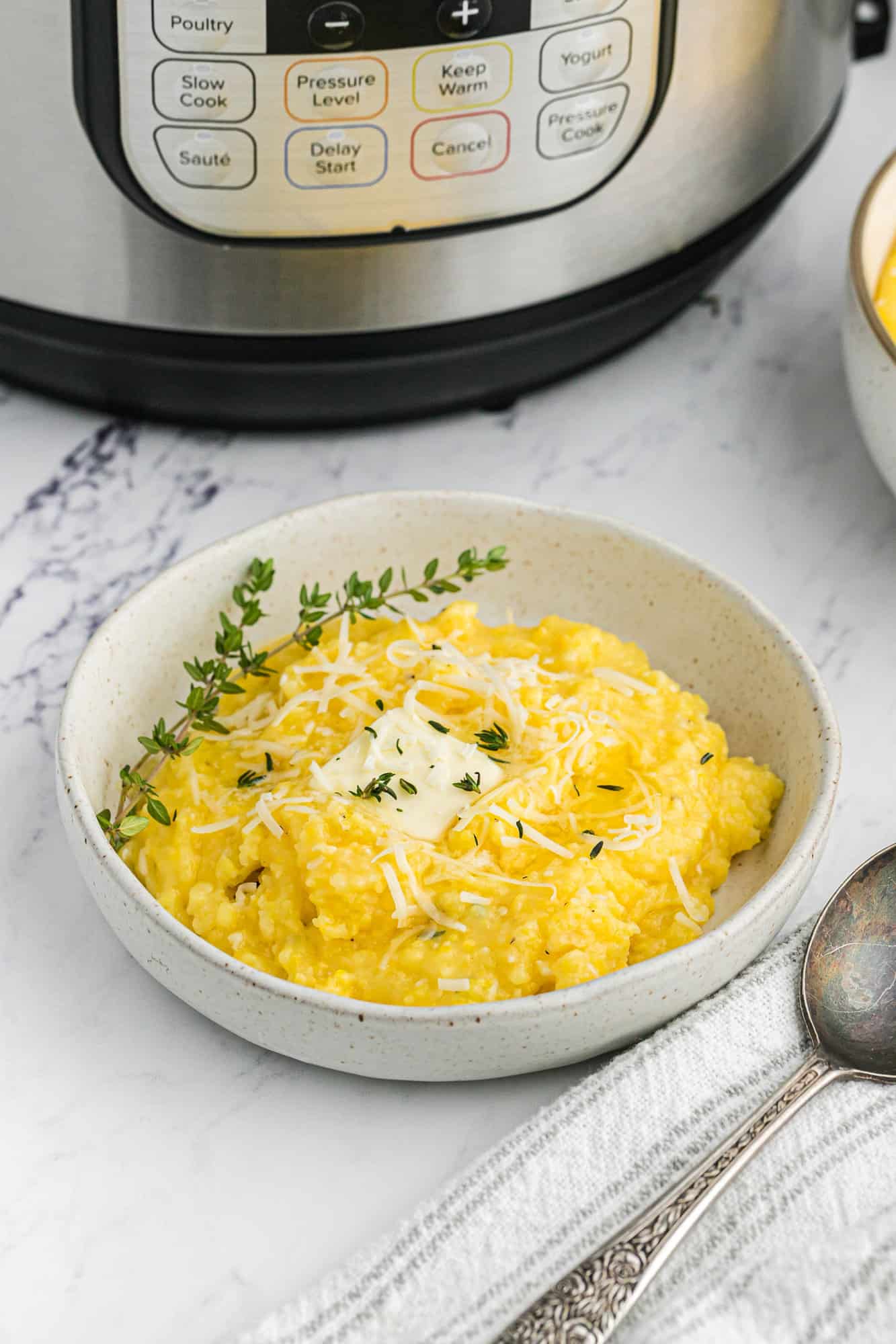 Polenta in bowl with instant pot in background.