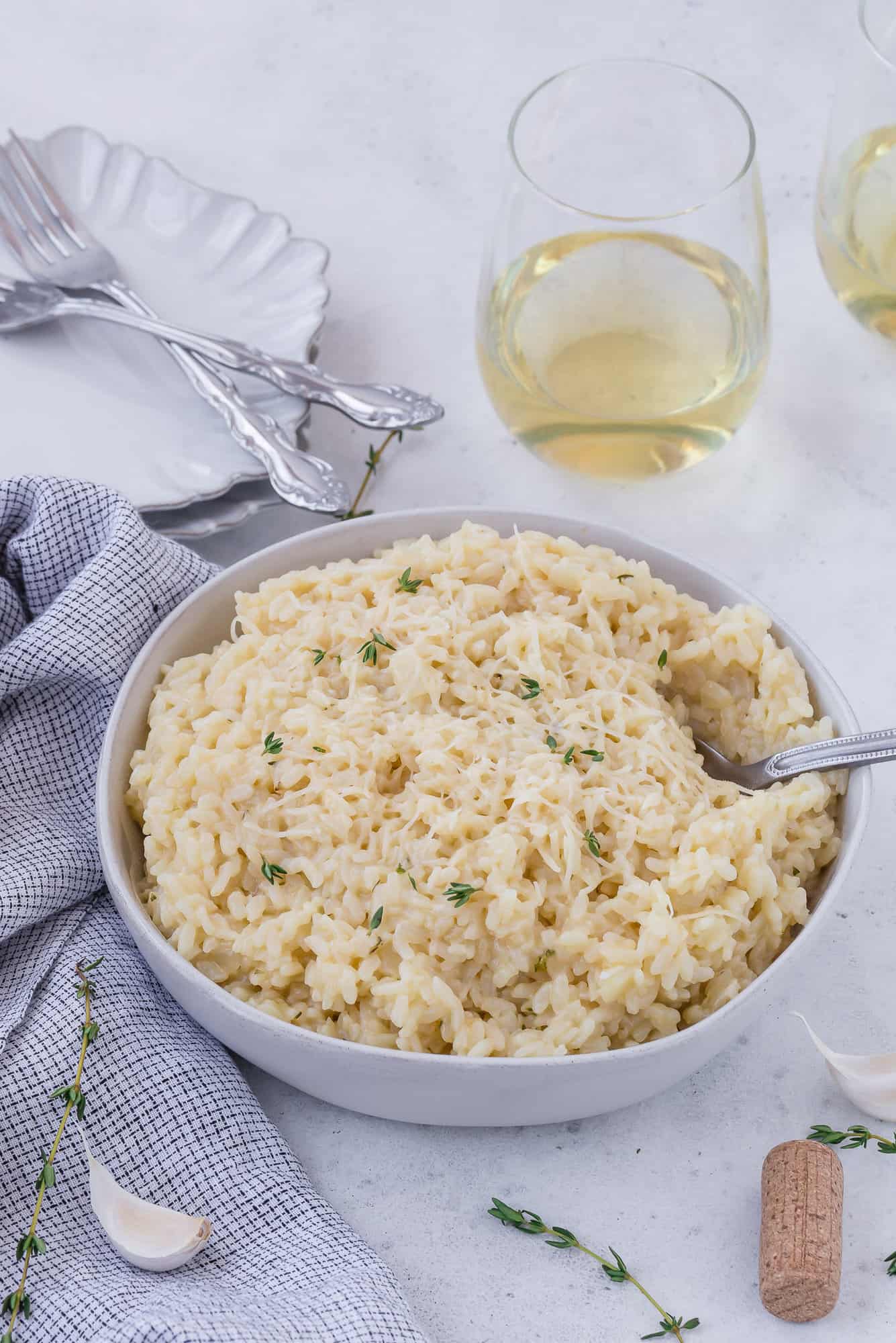 Risotto in a bowl with wine in background.