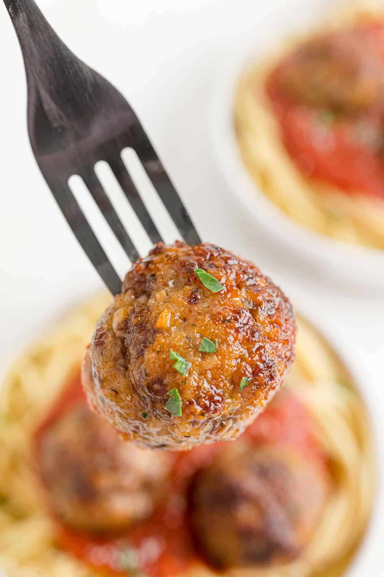 Perfectly browned meatball on a fork.