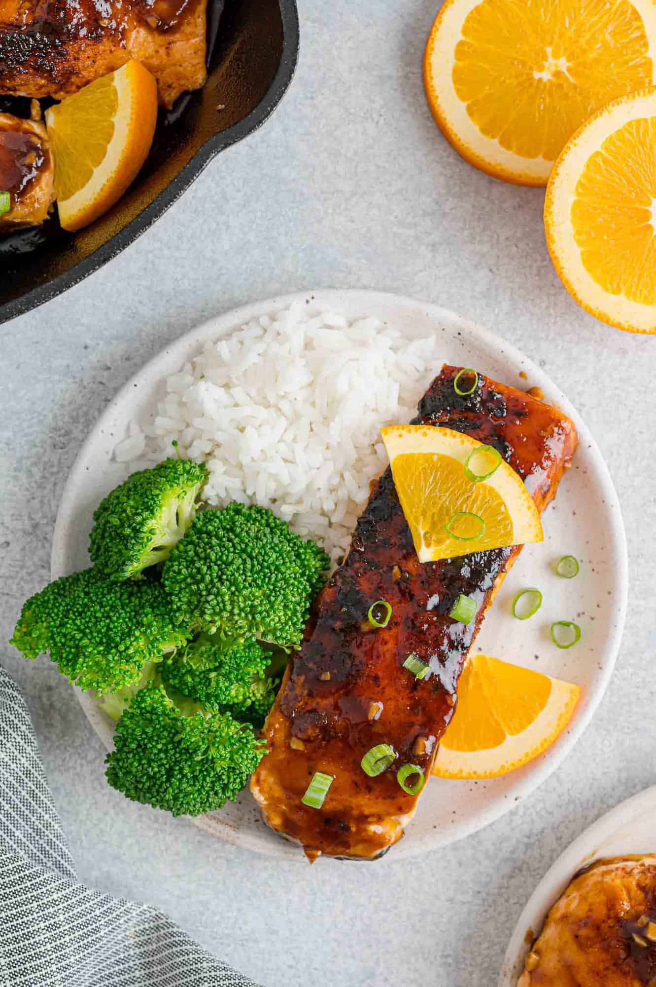 Overhead view of orange glazed salmon on a plate with rice and broccoli.