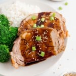 Two slices of slow cooker pork loin with balsamic glaze.