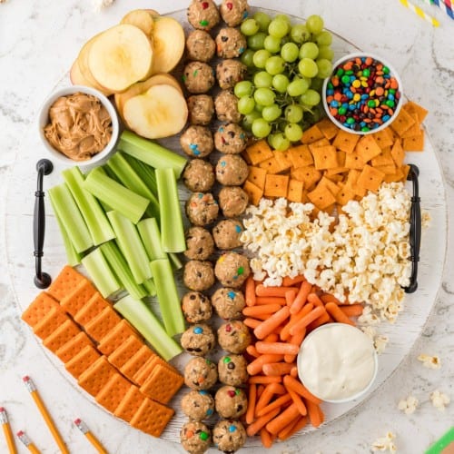 Round snack board with a variety of items.