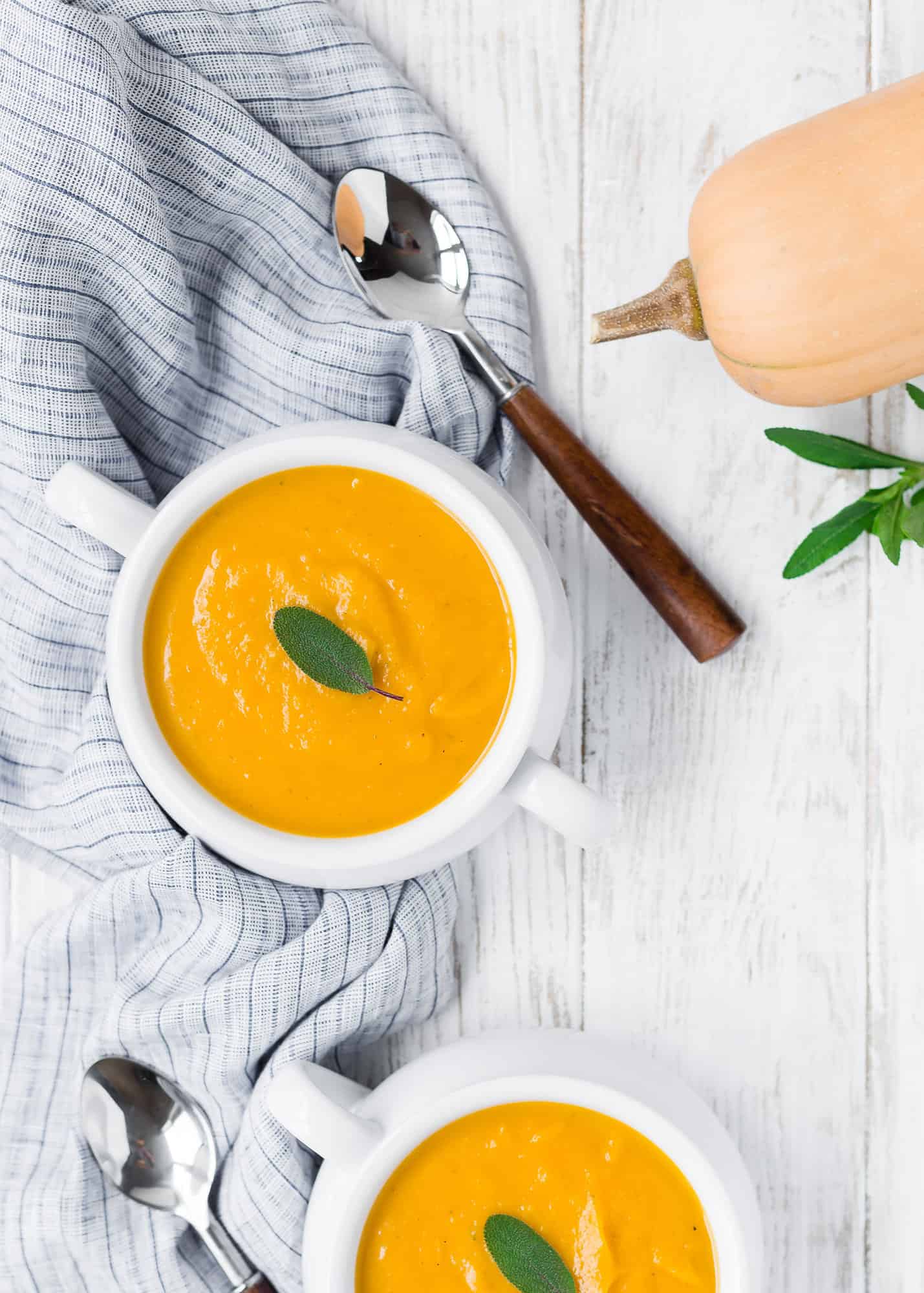 Overhead view of two bowls of soup with sage.