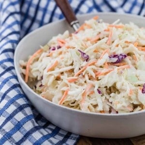 Creamy coleslaw in a bowl with a spoon.