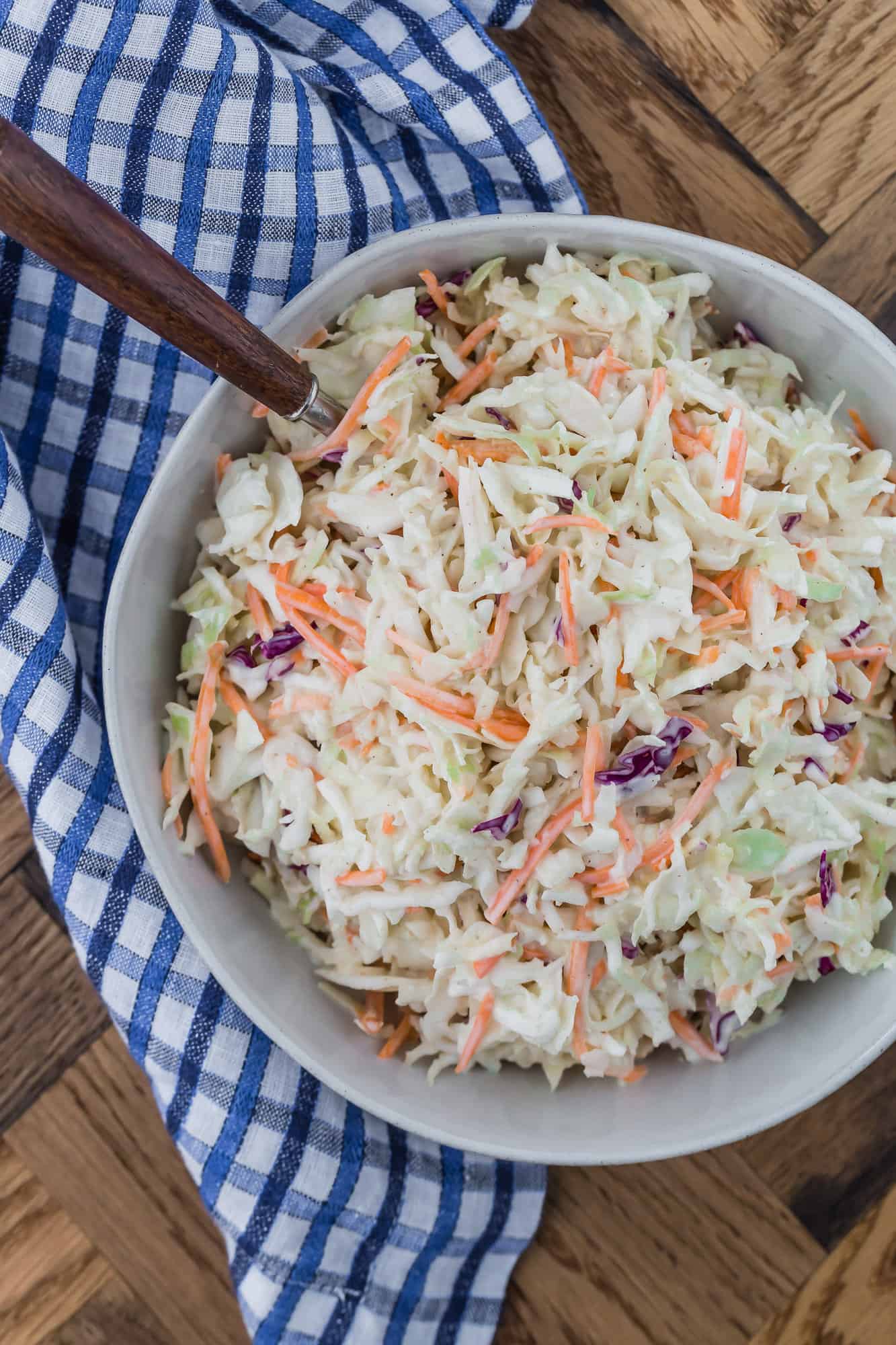 Coleslaw in a bowl with a blue and white linen.