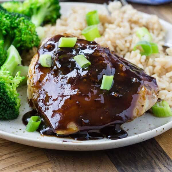 Honey balsamic chicken thigh on plate with broccoli and rice.