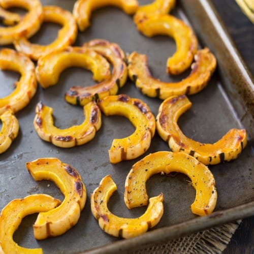 Roasted delicata squash on a sheet pan.