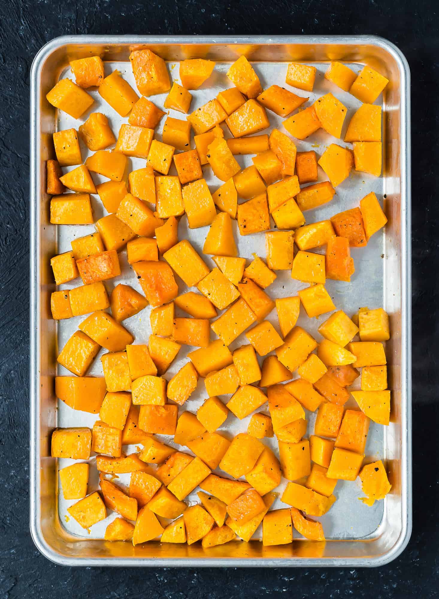 Diced roasted butternut squash on a sheet pan.