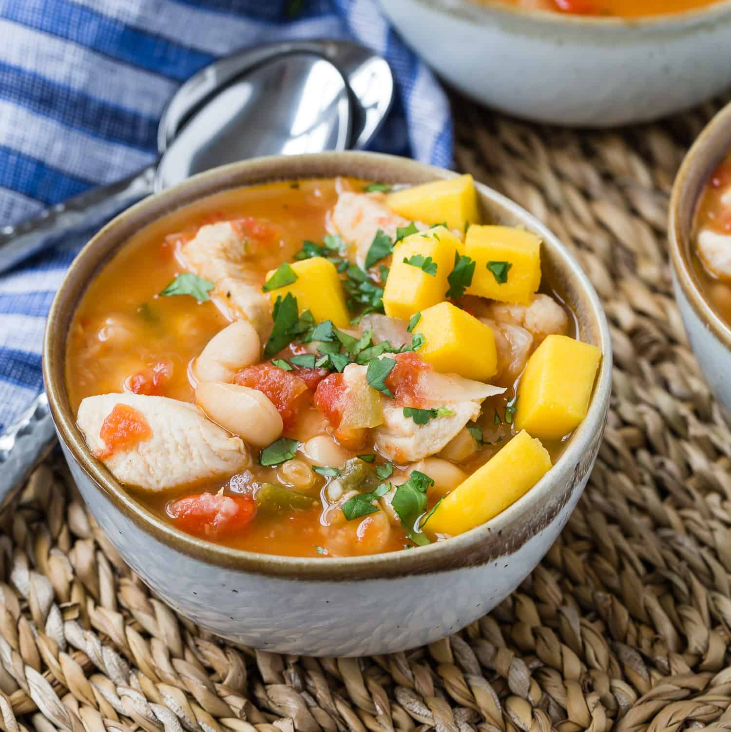 Chili in a bowl with mango and cilantro.