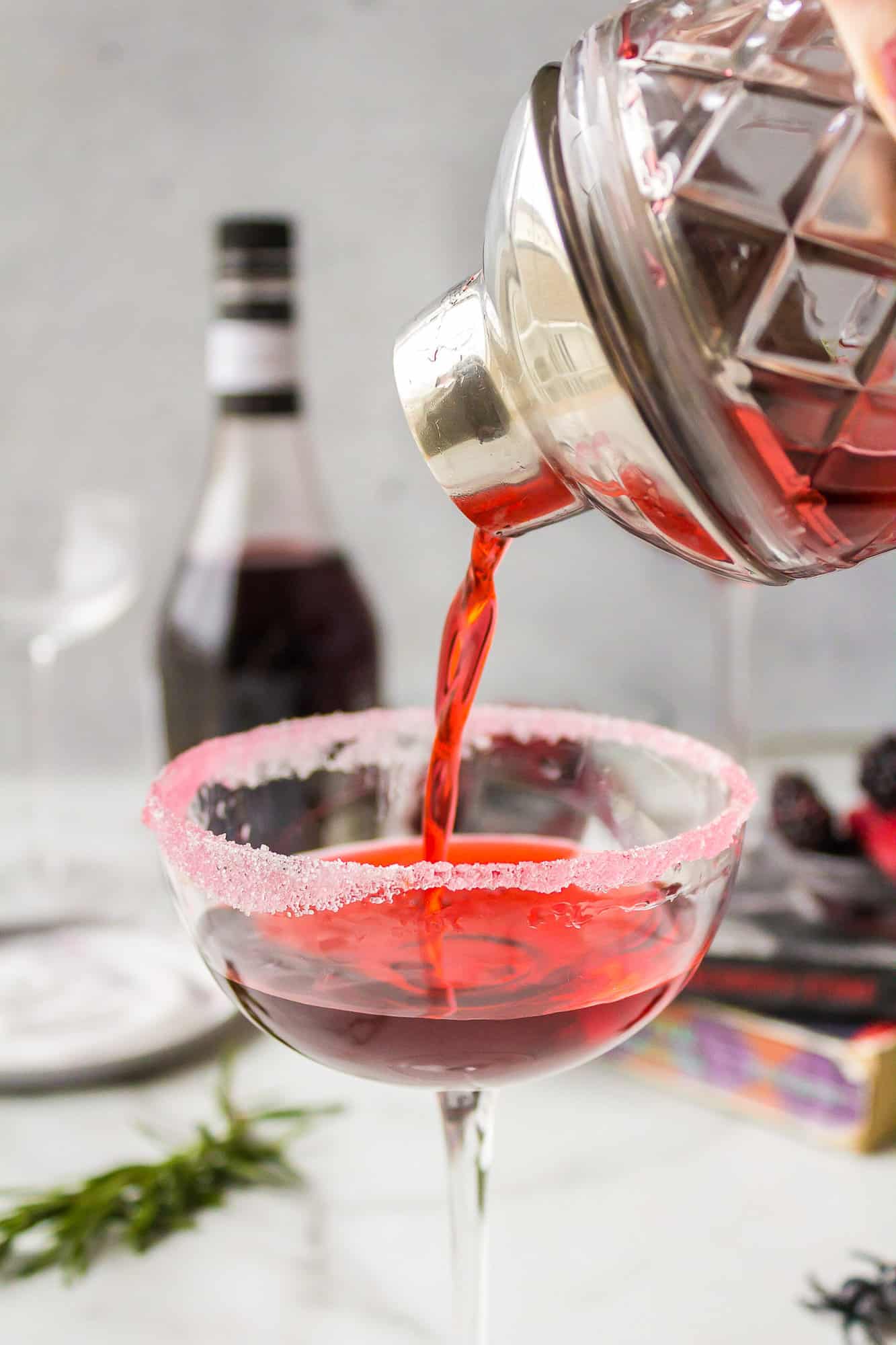 Cocktail being poured into couple glass.