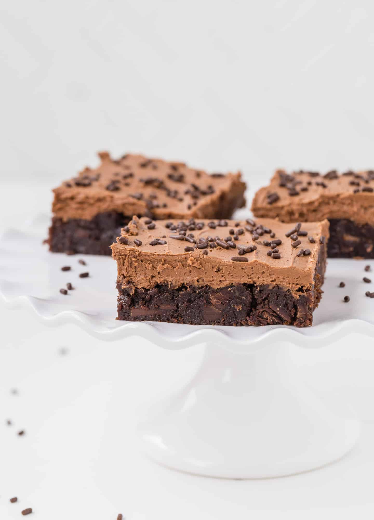 White plate with frosted brownies.