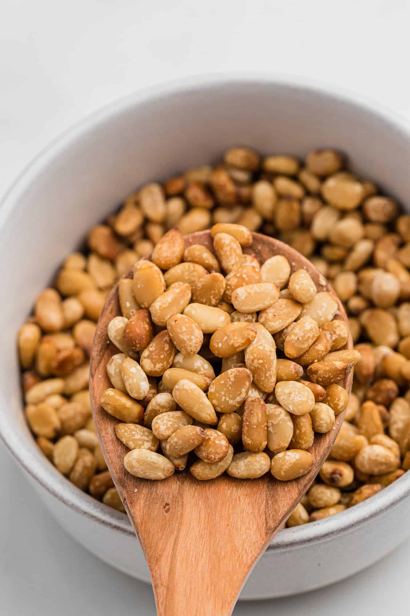 Toasted pine nuts in a small bowl.