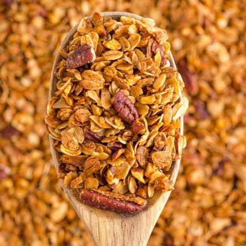 Granola on a wooden spoon, more in background.