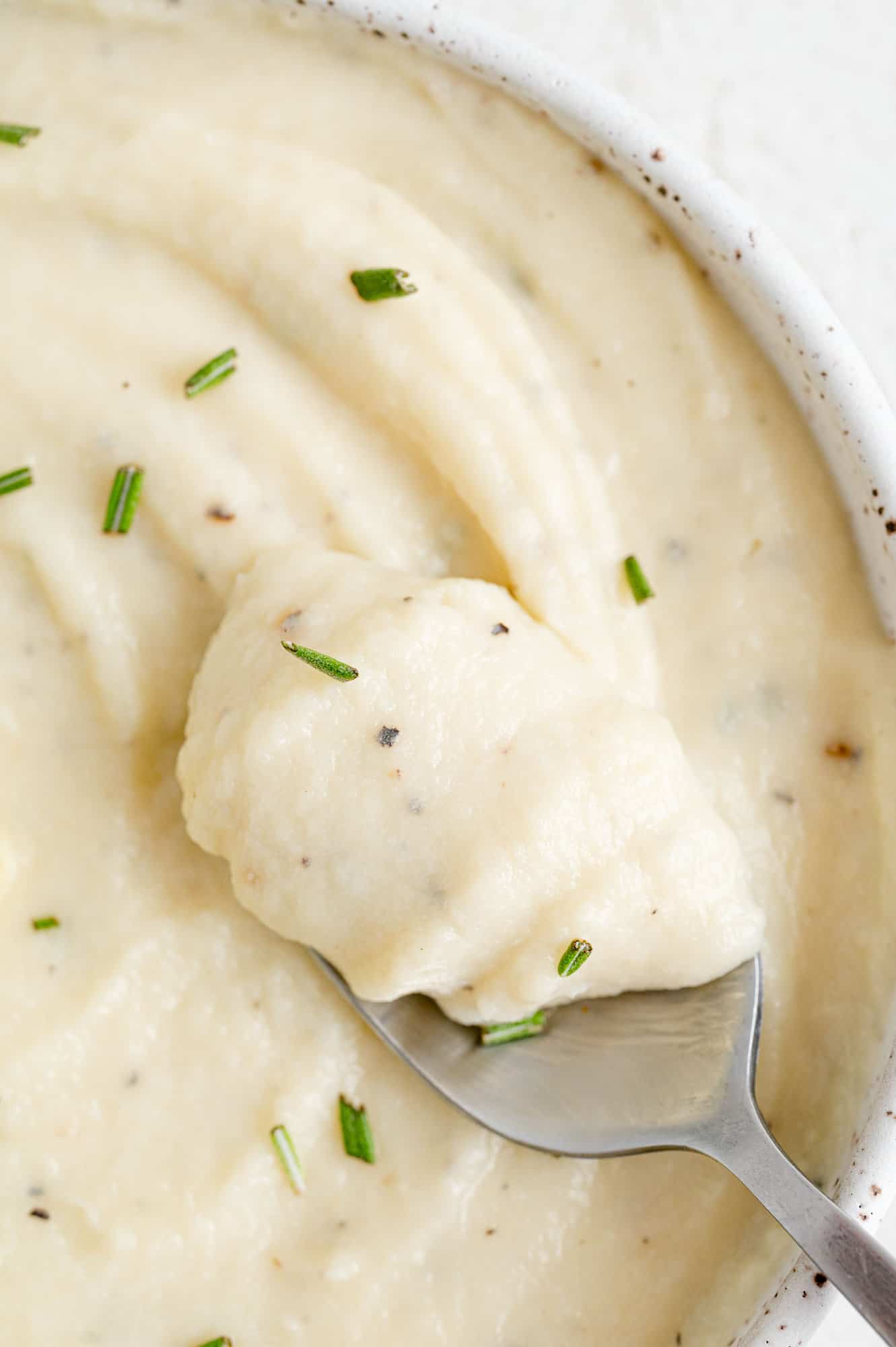 Parsnip puree on a spoon to show texture.