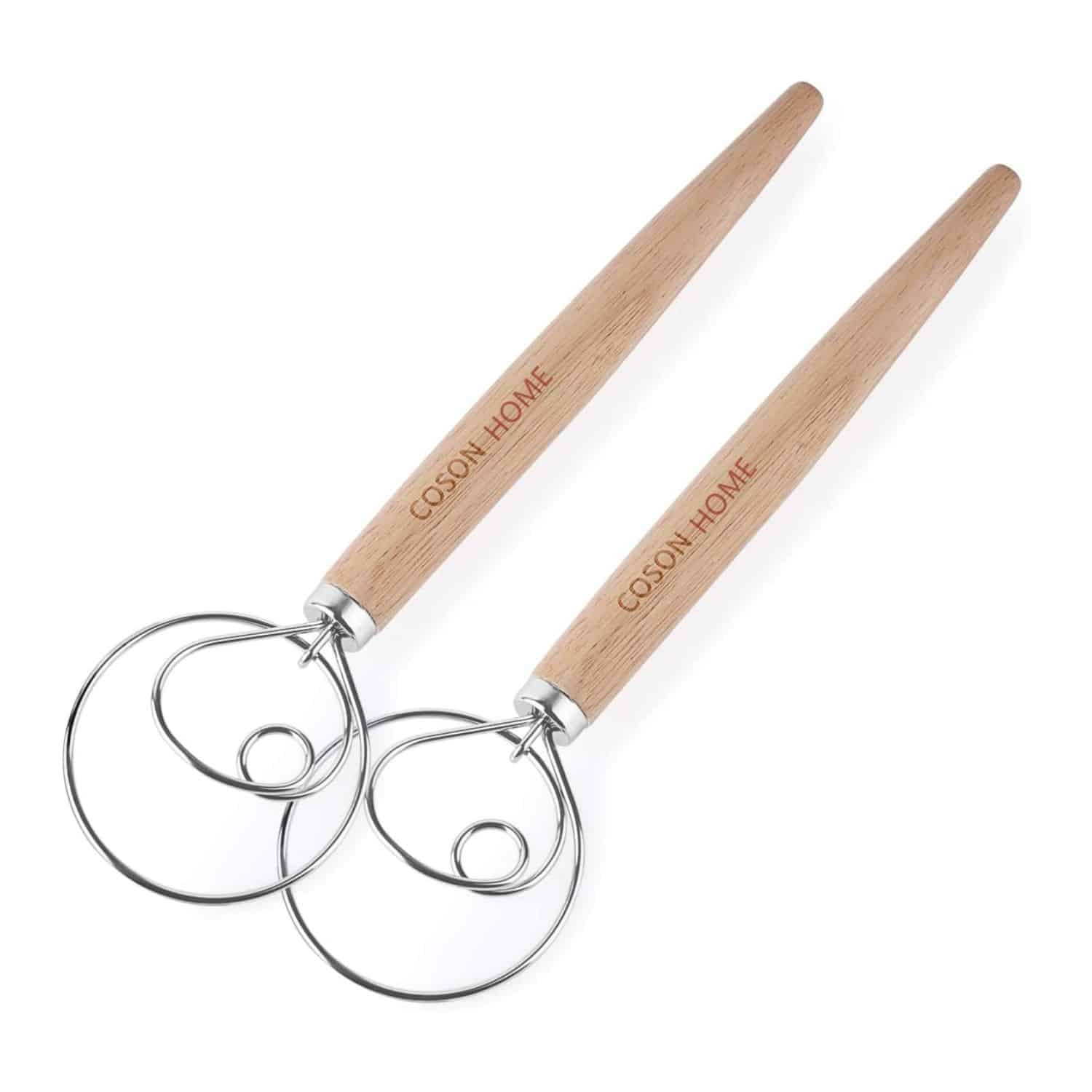 Two dough whisks against a white background.