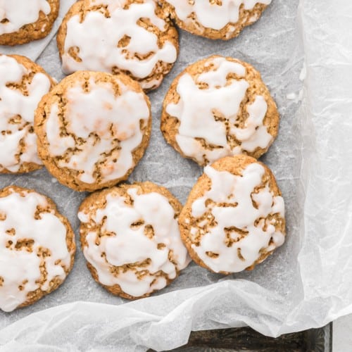 Iced oatmeal cookies on parchment.