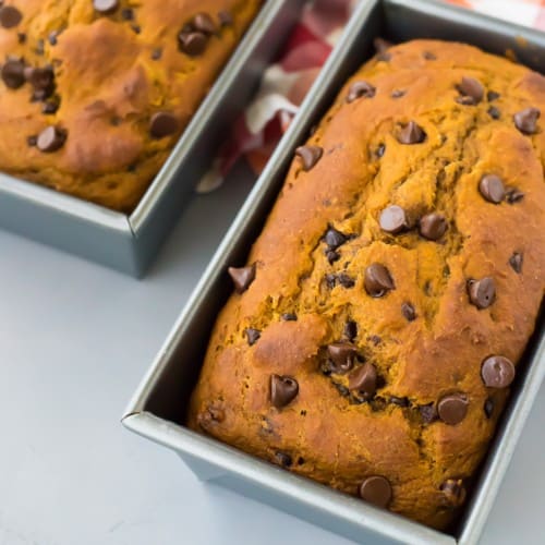 Two pumpkin chocolate chip bread loaves in loaf pans.