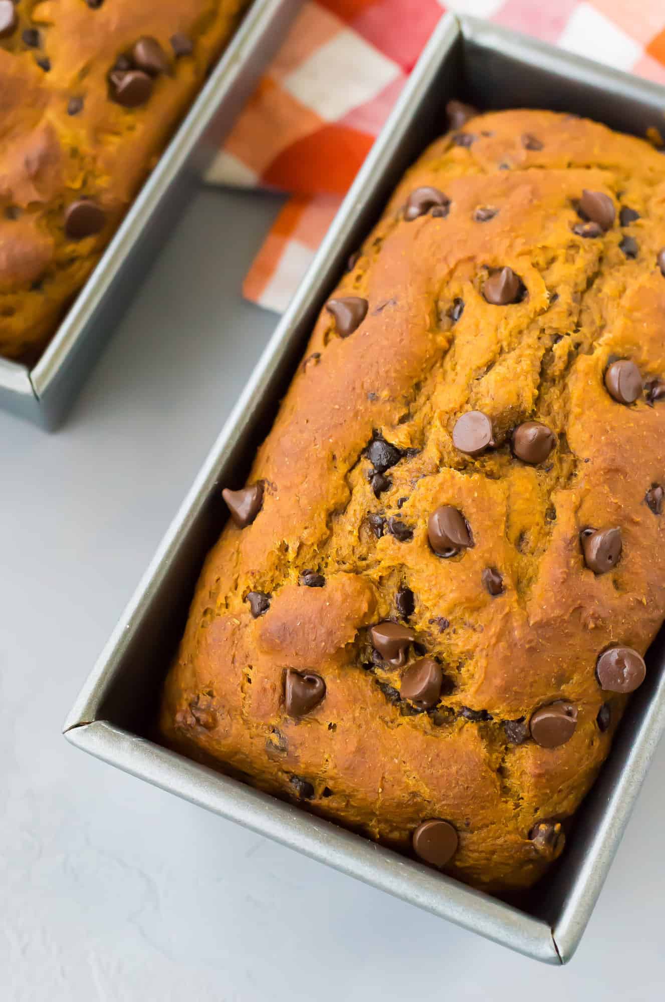 Close up of a pumpkin chocolate chip bread loaf in a loaf pan.