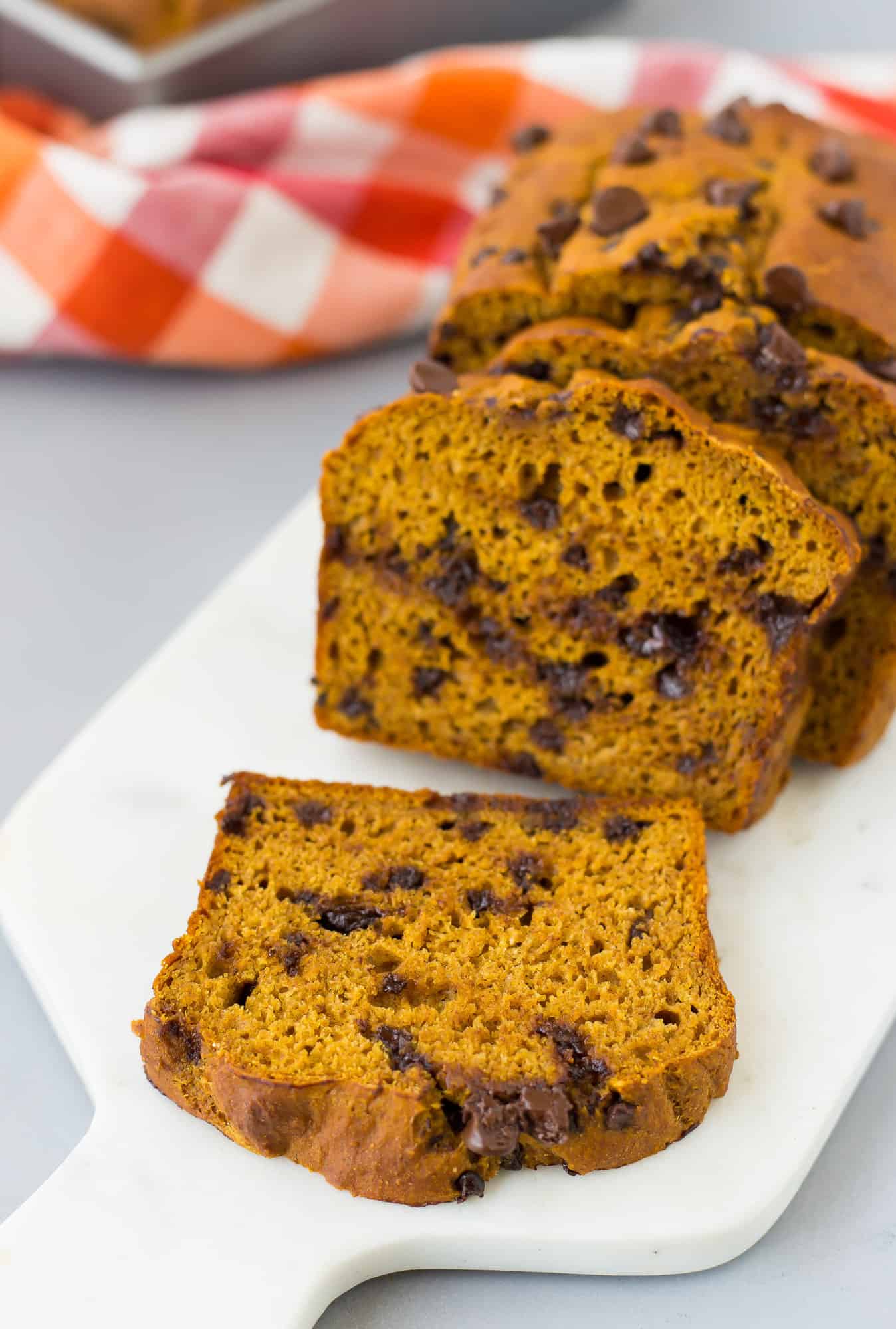 Sliced pumpkin chocolate chip bread on a cutting board.