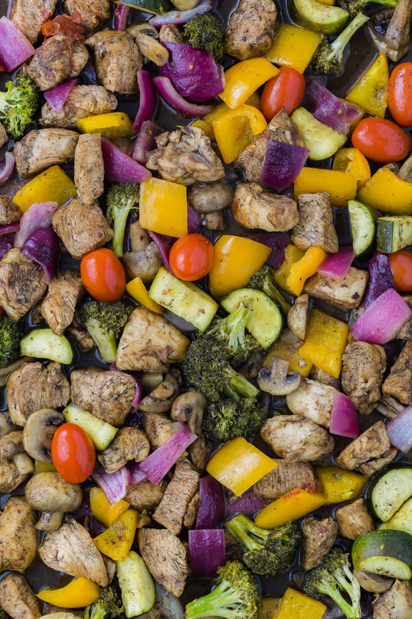 Chicken and vegetables with balsamic sauce on sheet pan.