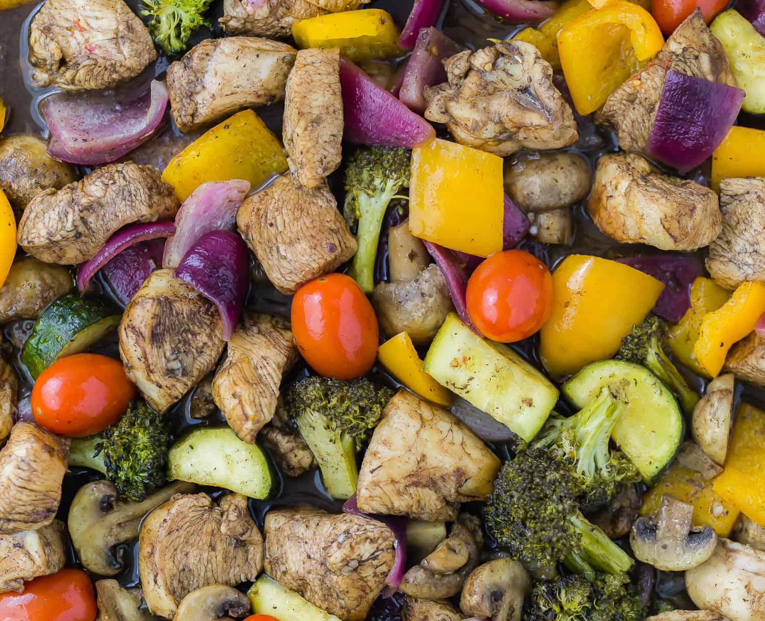 Vegetables and chicken on a sheet pan, close up.