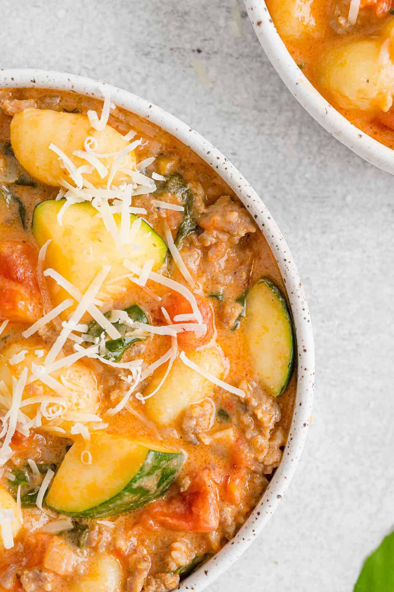 Partial view of creamy gnocchi in a bowl.