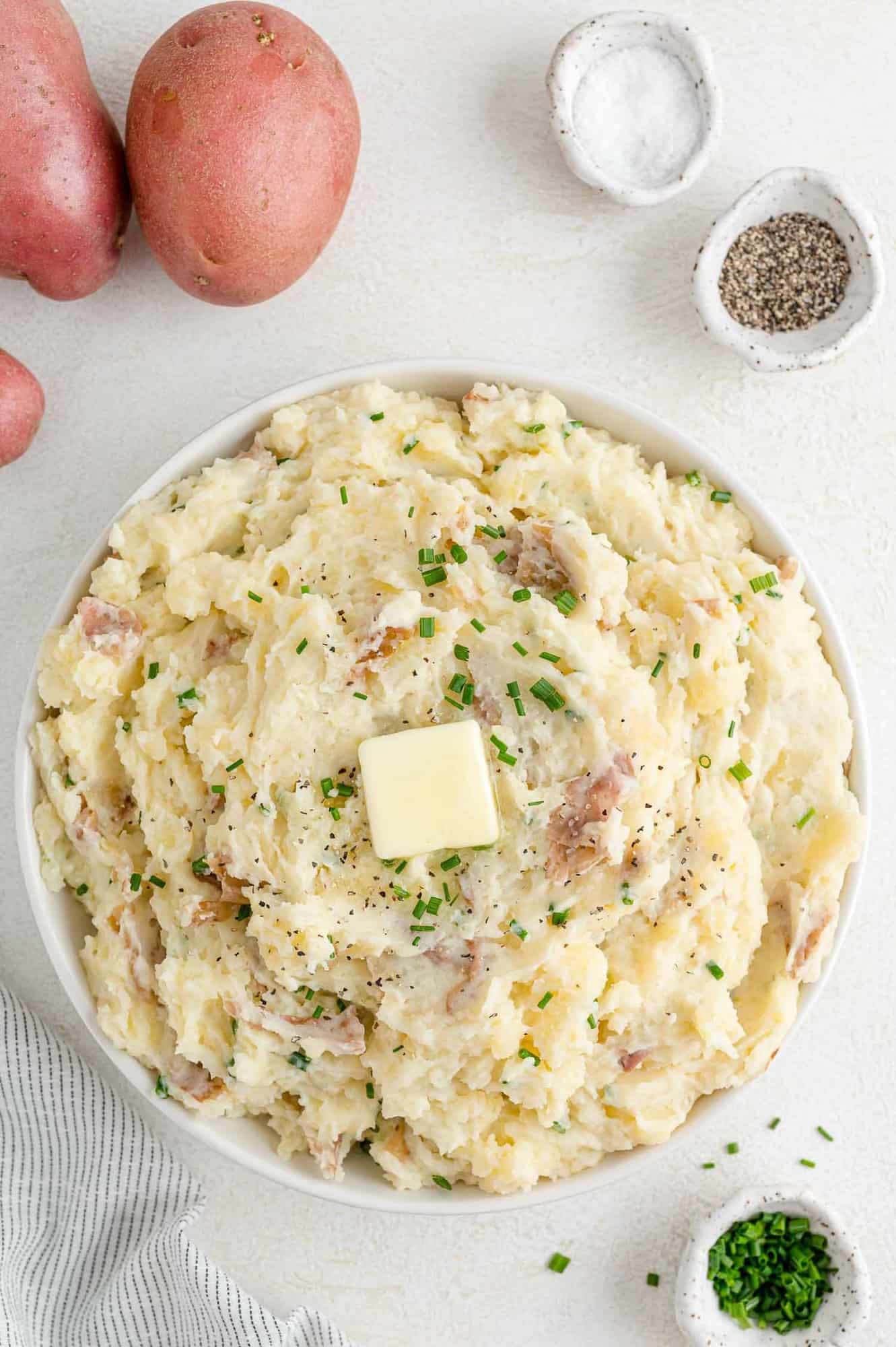 Mashed red potatoes topped with butter and chives.