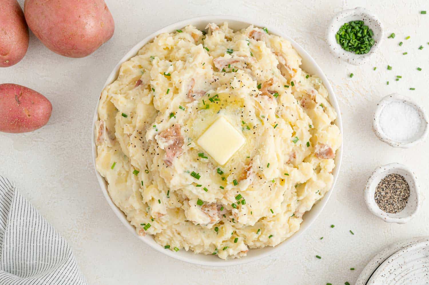 Large bowl of creamy mashed potatoes topped with butter.