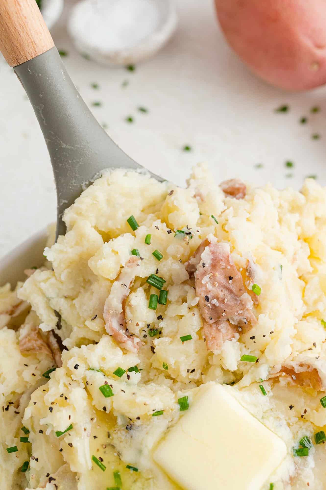 Mashed red skin potatoes being scooped.