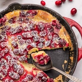 Cranberry clafoutis with a slice removed.