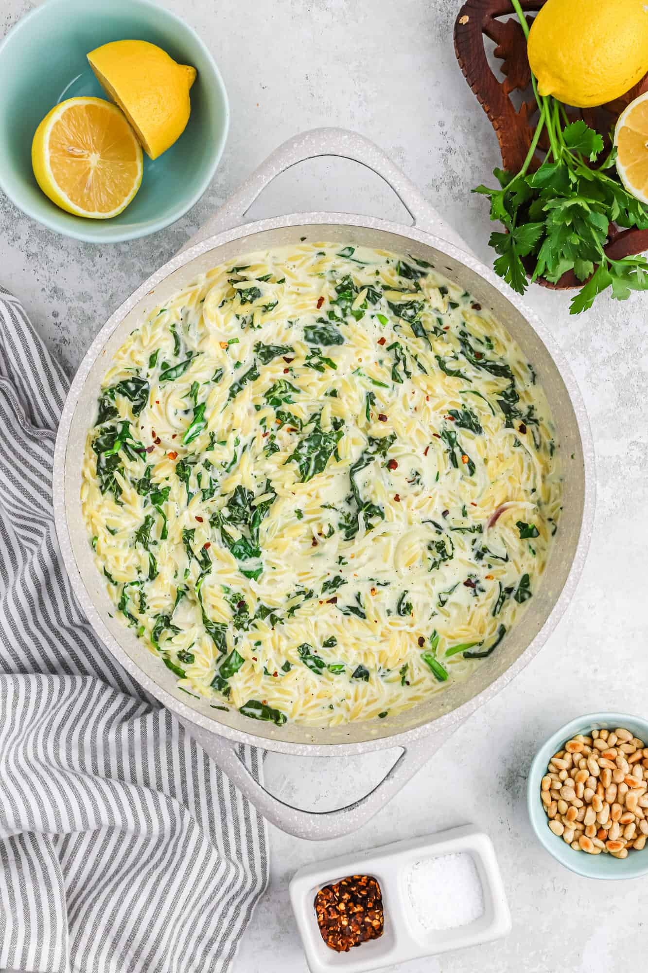 Creamy orzo with spinach in a large pan.