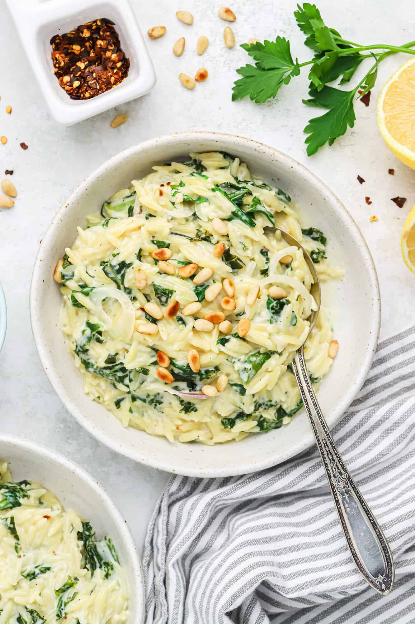 Creamy orzo and greens topped with pine nuts.