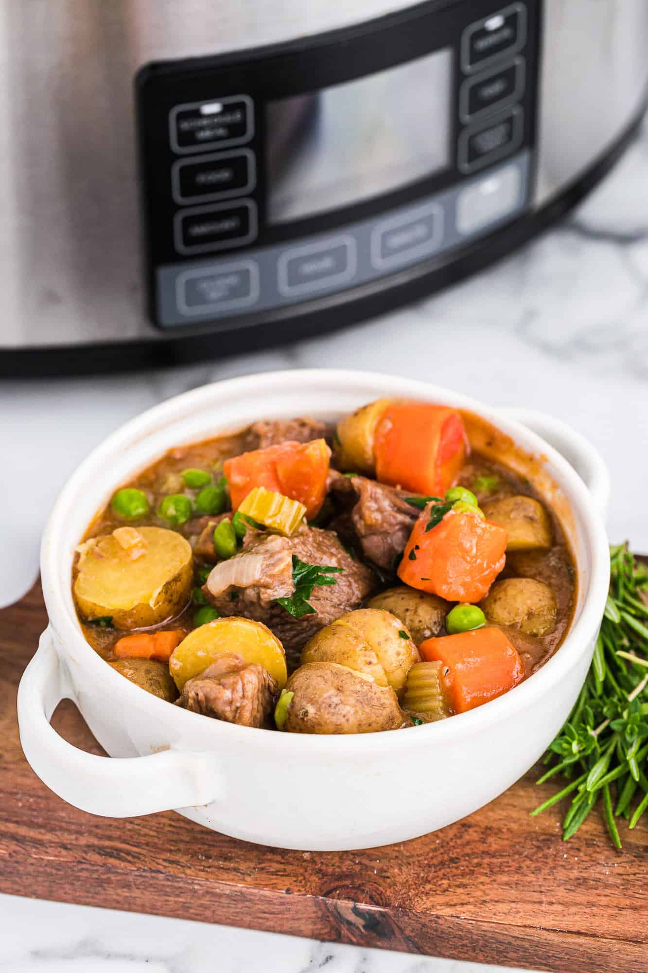Beef stew with a crockpot in the background.
