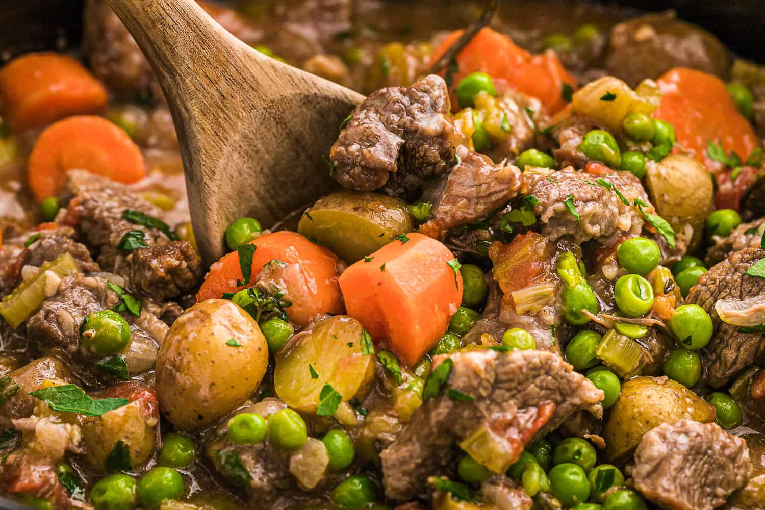 Beef stew with a wooden spoon.