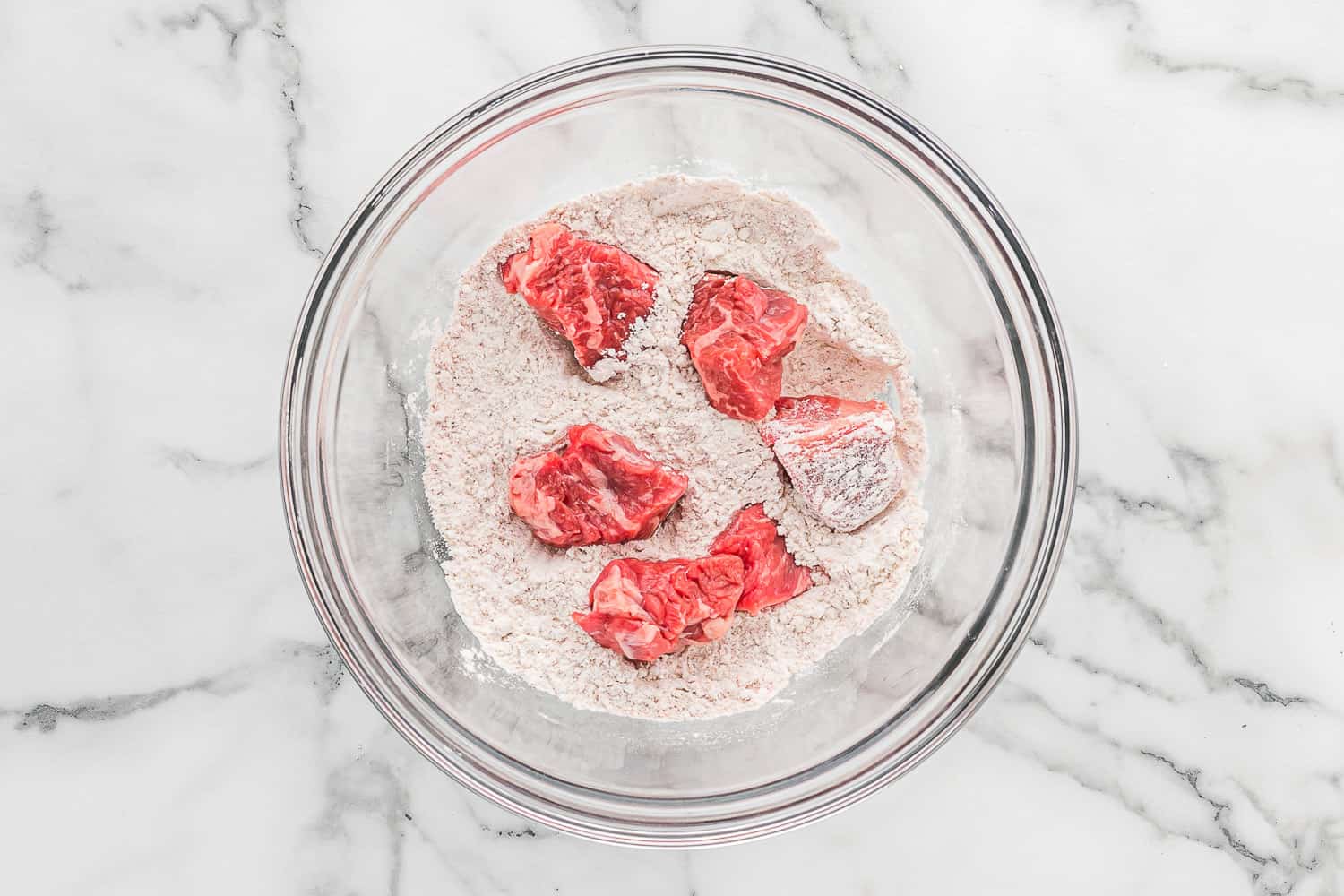 Beef being dredged in flour.