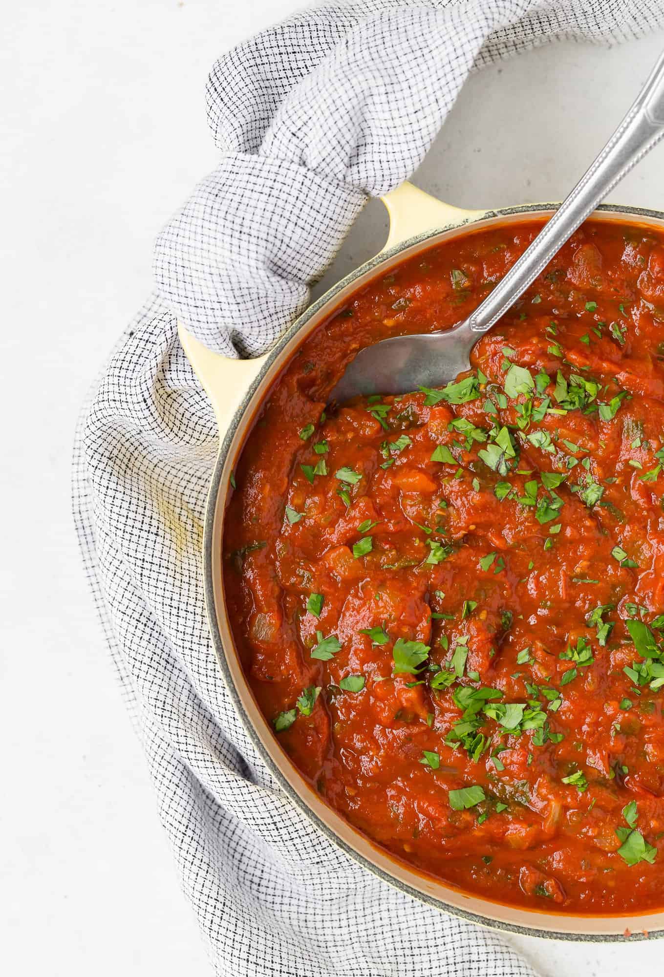 Spaghetti sauce in pan with large serving spoon.