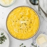 Instant pot polenta in a serving bowl with butter and thyme.